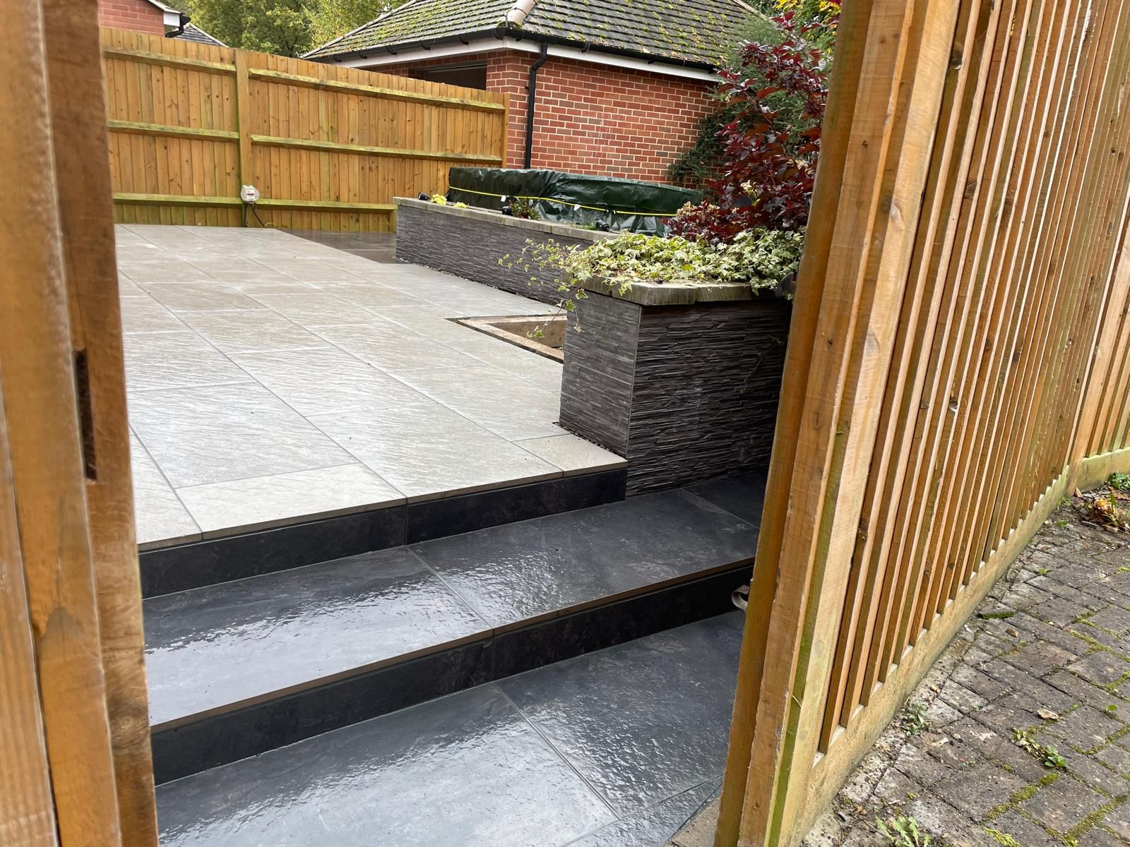 Dark porcelain patio with steps and gate view