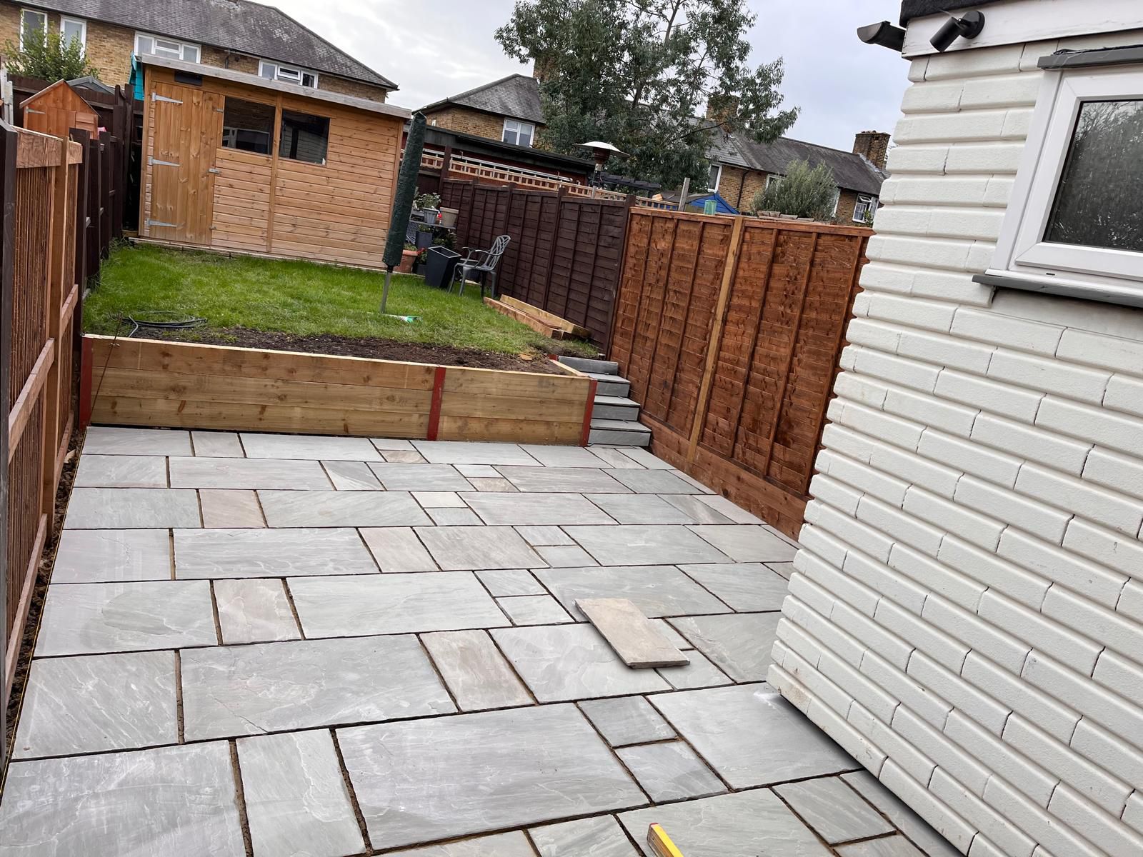 Natural stone patio with raised beds and fencing