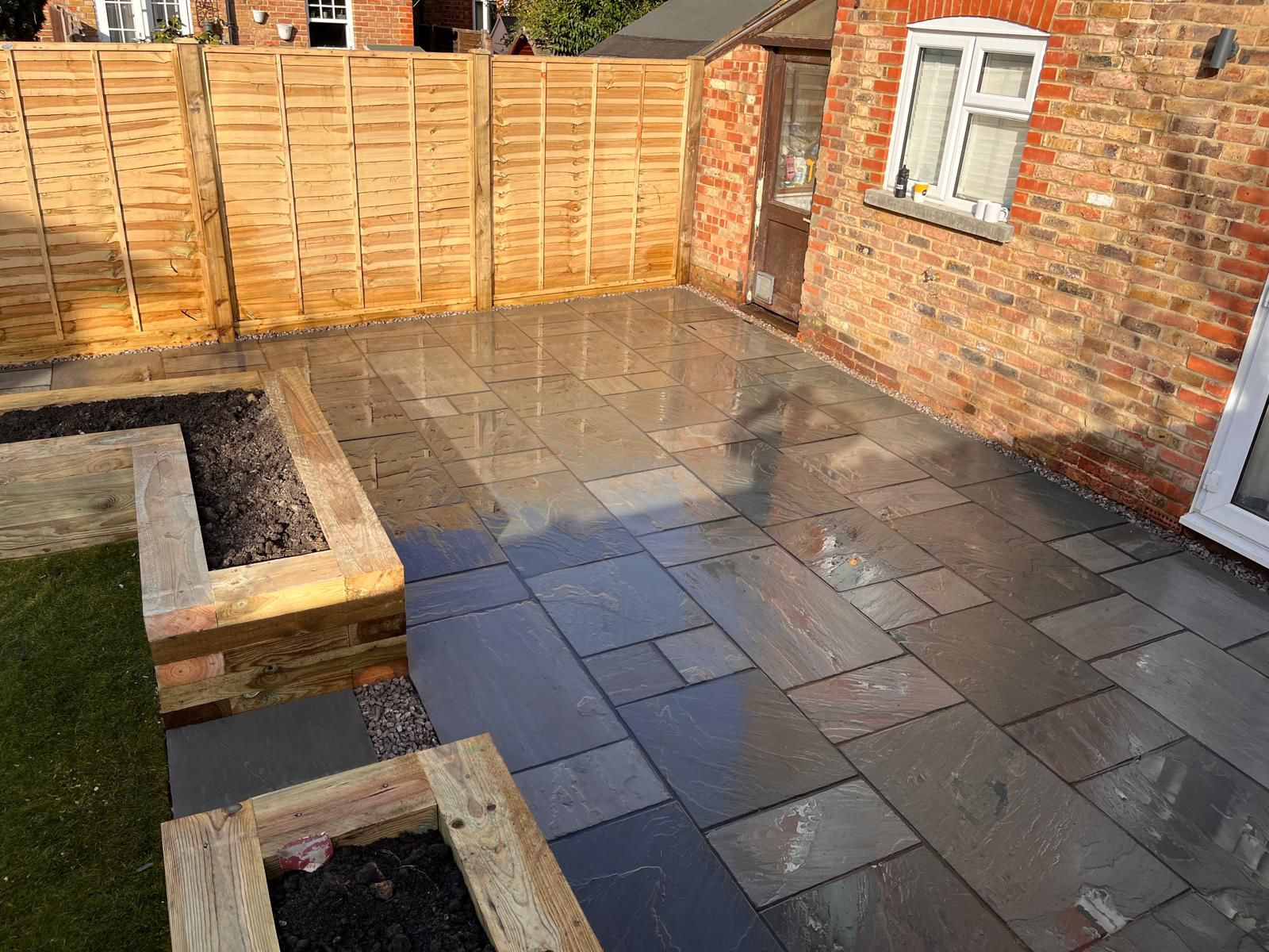 Slate patio with timber planters at dusk