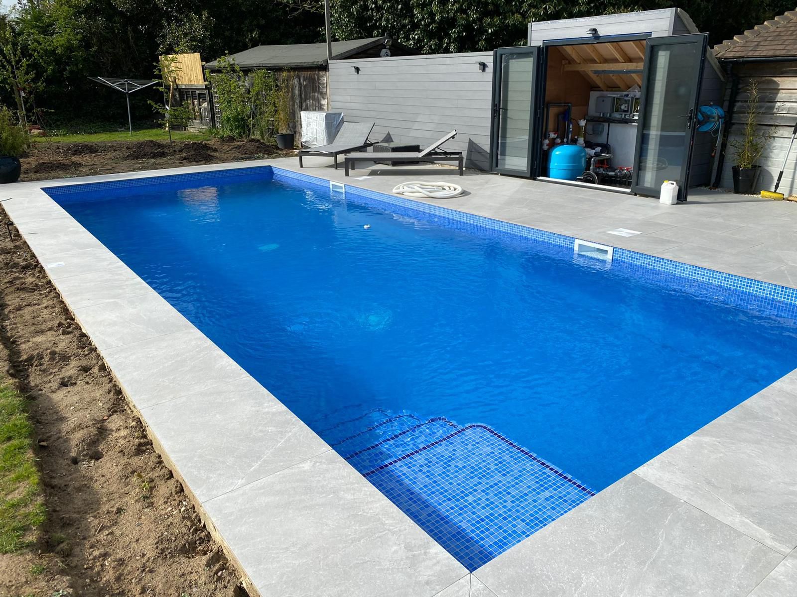 Blue tile swimming pool with pool house